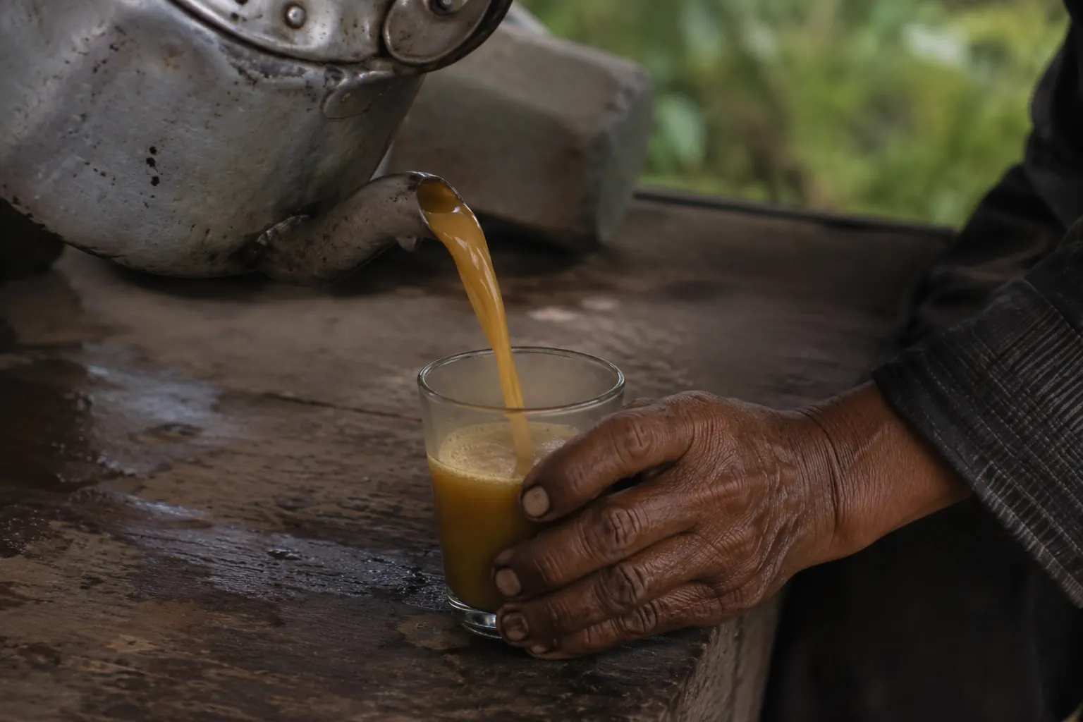 Jamu versé d'une théière traditionnelle dans un verre